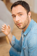 © Viacheslav Yakobchuk - Bad news. Disappointed sad young man gazing straight placed elbow on the knee while posing against the blurred background