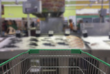 Fototapeta Nowy Jork - Supermarket aisle with empty shopping cart, Supermarket store abstract blurred background with shopping cart