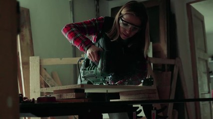 Wall Mural - Young woman worker in the carpenter workroom.