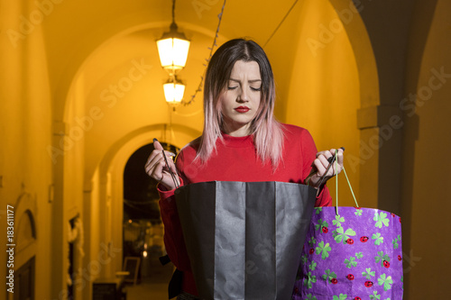 Fotografering Giovane ragazza che guarda perplessa l'interno della bag
