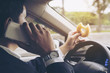 Man eating donuts while using mobile and driving car - multitasking unsafe driving concept
