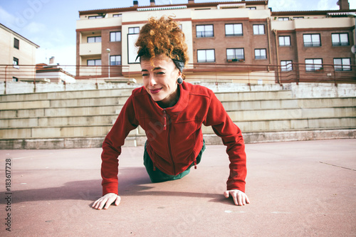 Fotomural Mujer joven que empieza a hacer ejercicio de flexiones