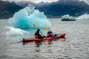 Two kayakers next to an iceberg in Prince William Sound, Alaska