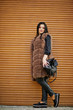 © AS Photo Family - Fashion outdoor photo of gorgeous sensual woman with dark hair in elegant clothes and luxurious fur coat and with backpack against shutter background.