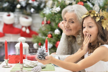 Wall Mural - girl with grandmother preparing for Christmas