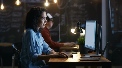 Poster - Beautiful Female Coder Works at Her Desktop on Her Peropnal Computer. Her Male Colleague Sits Next To Her. Evening Office Has Creative Lighting.