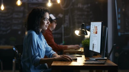 Poster - Beautiful Female Office Worker Browsing Social Networks Site, Scrolling Web Page Wall. Her Colleague Sits in the Background in this Creative Office. RED EPIC-W 8K Camera.