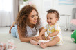 © Africa Studio - Cute baby and mother playing on floor at home