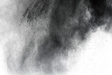 Wall Mural - Black powder explosion against white background.The particles of charcoal splatted on white background. Closeup of black dust particles explode isolated on white background.