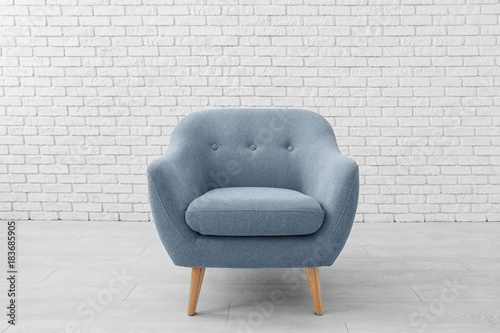 Fotografía Comfortable armchair near brick wall