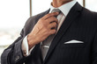 © Jacob Lund - Businessman adjusting his necktie