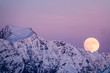 full moon rising in the evening sky in the Swiss Alps over a winter mountain landscape near Klosters