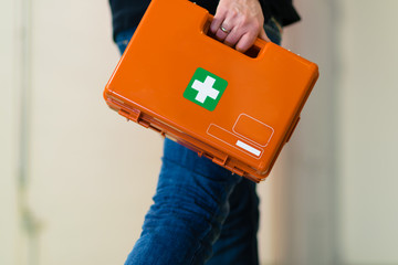 Man with first aid kit runs to help