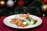 Fototapeta  - Caesar salad with chicken and parmesan cheese. Christmas or New Year's Eve dinner. Dinner with a Christmas tree. A festive dish for Christmas and New Year with champagne. Christmas tree background