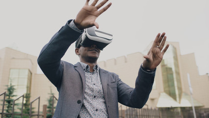 Young businessman having VR experience using 360 virtual reality headset outdoors