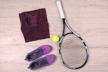 Poster - Tennis racket, ball, clothes and shoes on wooden background