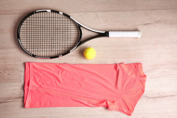 Canvas Print - Tennis racket, ball, clothes and shoes on wooden background