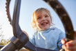 © Connect Images - Young girl holding tractor's steering wheel, low angle view