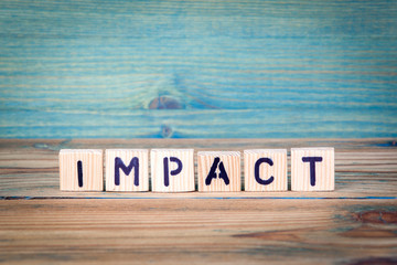 impact - name from wooden letters. office desk, informative and communication background.