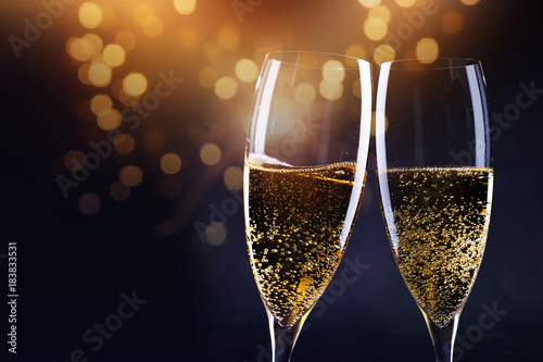 Fotografía two champagne glasses ready to bring in the New Year - holiday lights and firewo