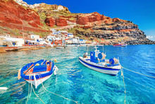 Greece. Breathtaking Beautiful Landscape Of Two Fishing Boats Anchored To Quay In Fascinating Blue Water At The Amazing Old Port Panorama In Oia Ia Village On Santorini Greek Island In Aegean Sea.