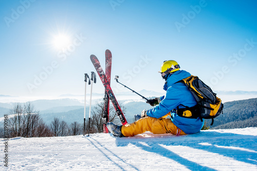 Dekoracja na wymiar  ujecie-z-tylu-narciarza-siedzacego-na-sniegu-na-szczycie-gory-i-robiacego-sobie-selfie