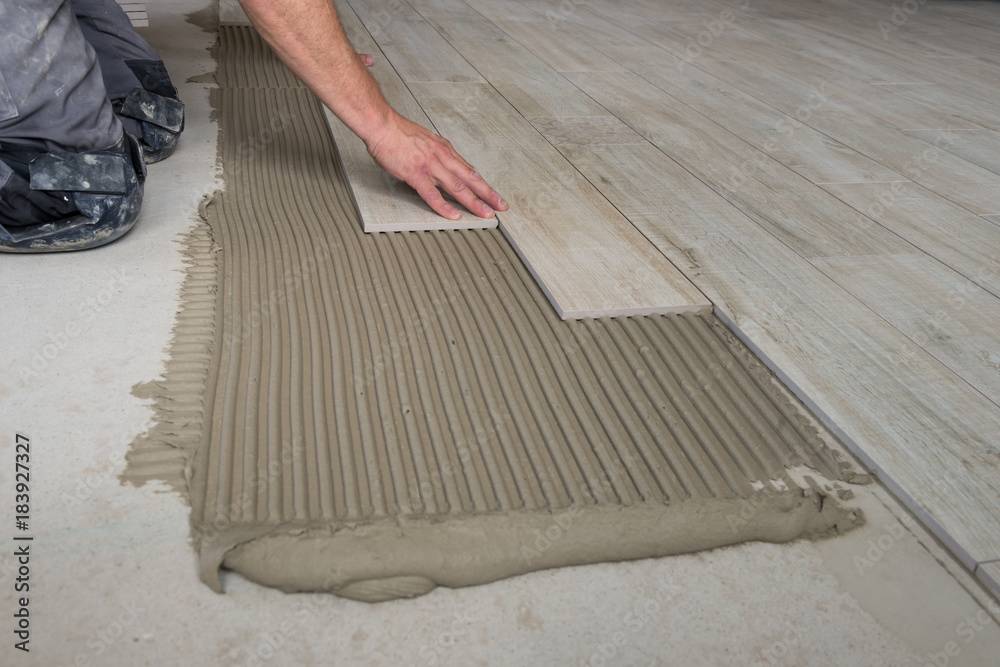 Keramische Platten werden am Boden verlegt.