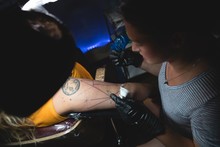 Professional Tattoo Artist Makes A Tattoo On A Womans Hand