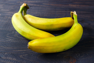 Poster - A few bananas on a black wooden background