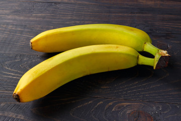 Poster - A few bananas on a black wooden background