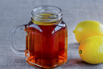 Black or herbal tea with lemon on a old wooden background.