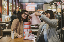 Happy Pregnant Woman Meeting With A Friend With Gifts For Her Baby
