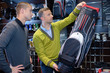 Men looking at golf club bag in sports shop