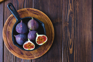 Wall Mural - Fresh and ripe figs inside frying pan over wooden table.