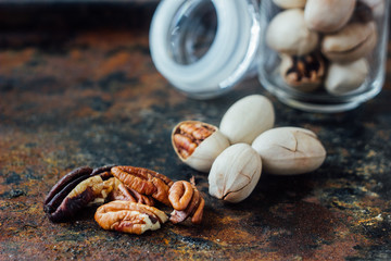 Poster - Pecan nuts inside glass jar on rustic surface.