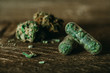 © nokturnal - Medizinisches Cannabis Kapseln und Knospen auf Holz