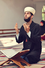 Wall Mural - Muslim man and woman praying for Allah in the mosque together