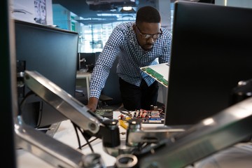 Computer engineer repairing motherboard at desk