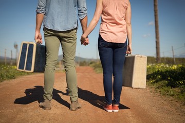 Couple walking with their luggage on a sunny day