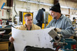 © Jetta Productions/Stocksy - Two men in factory looking at blueprints close up