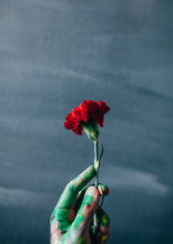 Painted Hand Holding A Red Carnation