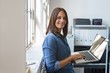 © contrastwerkstatt - frau steht im büro am fenster und arbeitet am notebook