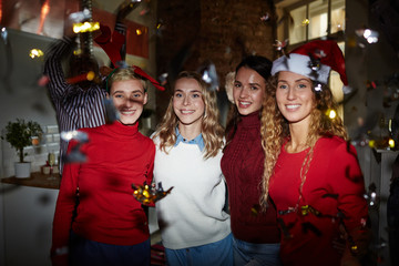 Poster - Company of affectionate girls in sweaters embracing on background of ecstatic friends