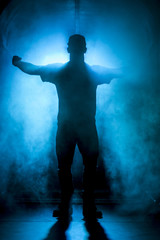 Wall Mural - Silhouette of a man in fog blue light