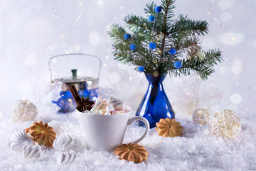 Wall Mural - A cup of hot cocoa with marshmallow or coffee with cinnamon and sweet cookies on the snow background