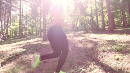 Wall Mural - A girl jogging in the woods outdoors. Healthy lifestyle.