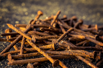 Pile of rusty used nails on the ground focus on the cottonwood seed blur background