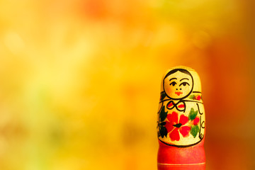 Wall Mural - Smallest Russian doll matryoshka on colored background