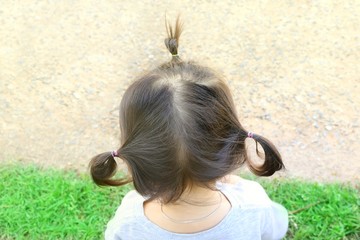 back of a little Asian girl about two years old, view three topknot black hair style