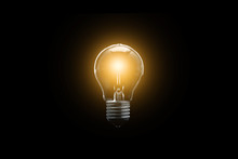 The Electric Bulb Is Glowing On A Dark Background. The Concept Is A Successful Idea.